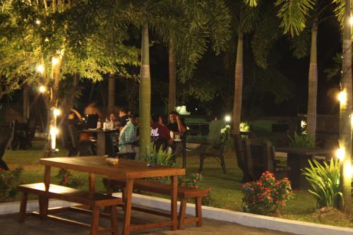a table and benches in a park at night at Grand Palace Hotel, Seeduwa in Seeduwa