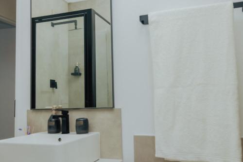a bathroom with a white sink and a mirror at Chanty Serenity Apartment with Pool and Gym in Sandton