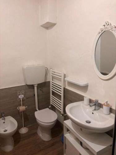 a bathroom with a toilet and a sink and a mirror at Affittacamere In centro in Gubbio