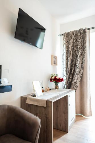 a room with a desk with a television on a wall at Bio B&B La Scoperta del Pollino in Laino Castello