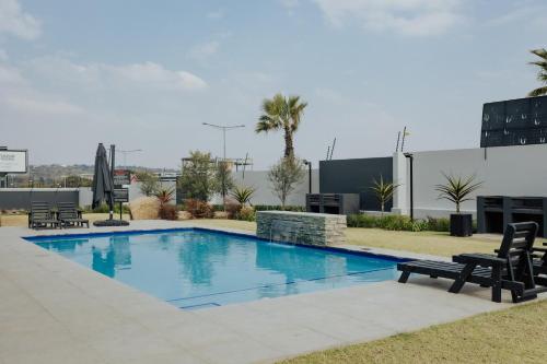 a large swimming pool with two chairs next to a building at Chanty Serenity Apartment with Pool and Gym in Sandton