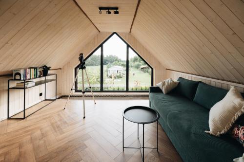 a living room with a green couch and a camera at Wyspa Roztocze in Kulików