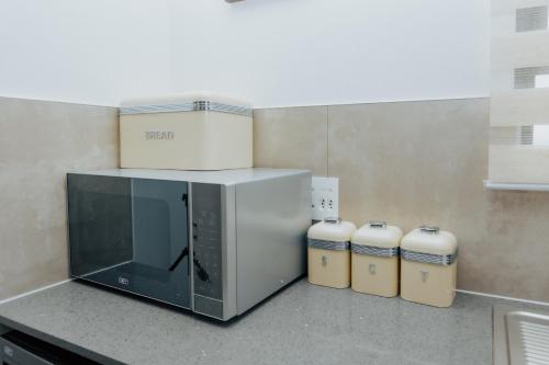 a microwave oven sitting on a counter with two small containers at Chanty Serenity Apartment with Pool and Gym in Sandton