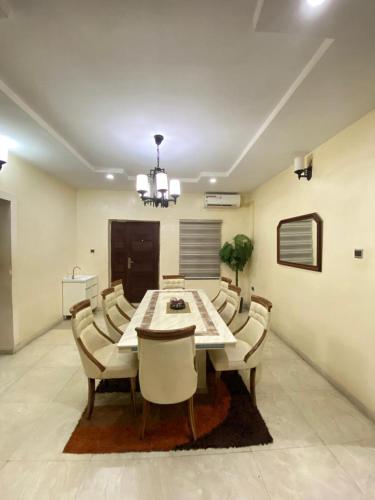 a dining room with a table and chairs at Luxury and Cozy family home in Ibadan