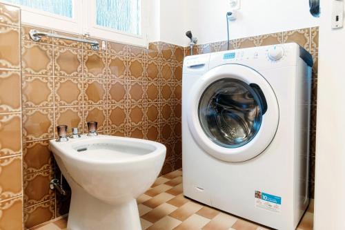 a bathroom with a washing machine and a toilet at The Secret Garden by Quokka 360 - flat in the hamlet of Mount Brè in Brè sopra Lugano