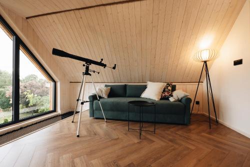 a living room with a couch and a telescope at Wyspa Roztocze in Kulików