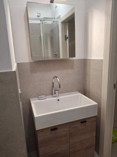 a bathroom with a white sink and a mirror at Apartment Centre nhe in Lecco