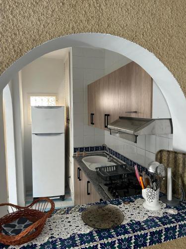 a kitchen with a white refrigerator and a counter top at Bungalow MARINA sousse KANTAOUI in Sousse