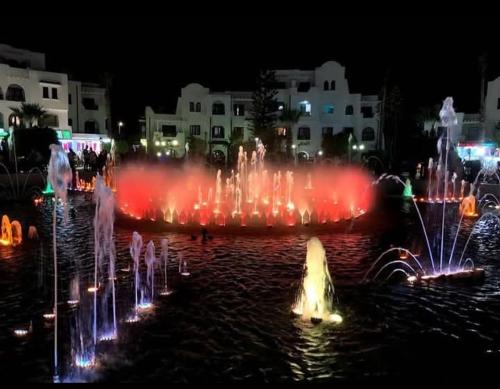 a fountain in the water at night with lights at Bungalow MARINA sousse KANTAOUI in Sousse