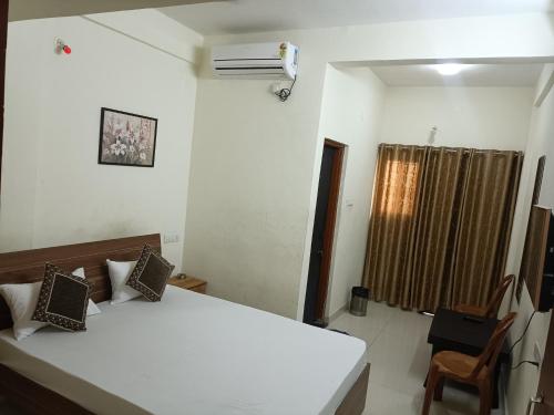 a bedroom with a white bed and a fan at Pride Hotel in Ranjangaon