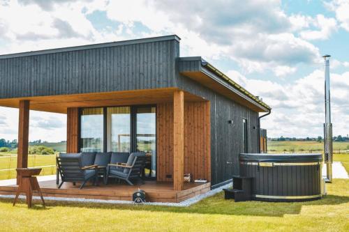 a small house with a deck and a grill at Vilkiškių Karpis Glamping in Vilionys