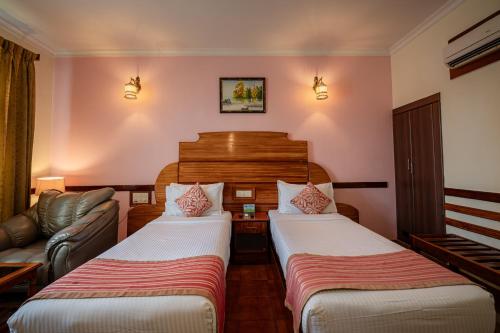 a hotel room with two beds and a couch at Hotel Presidency Kempegowda International Airport Bangalore in Devanahalli-Bangalore
