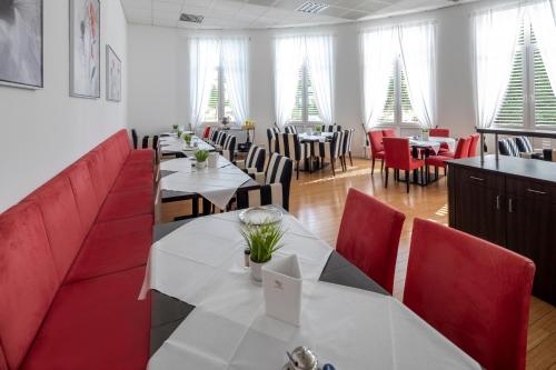 un restaurant avec des tables, des chaises et des arbres de Noël dans l'établissement Hotel Artrium am Park, à Dietzenbach