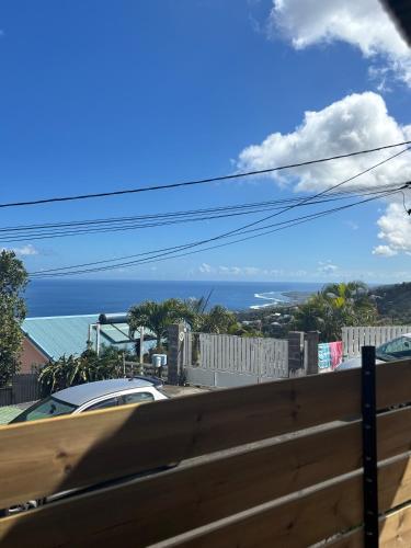 a view of the ocean from a fence at La KAZ Nout Racines in Saint-Leu