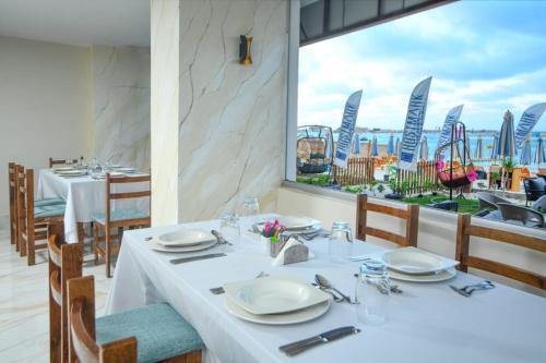a table in a restaurant with a view of the ocean at Hostmark Blue Beach Hotel in Marsa Matruh