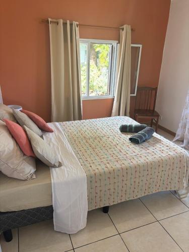 a bedroom with a bed with two shoes on it at La KAZ Nout Racines in Saint-Leu
