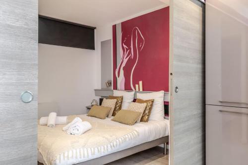 a bedroom with a bed with a red wall at Gites Spa Strasbourg - Appartement in Furdenheim