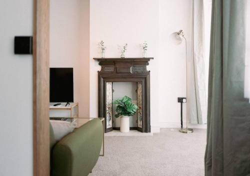 a living room with a fireplace and a television at Ye Old Shop Milton by Sheppey Stays in Kent