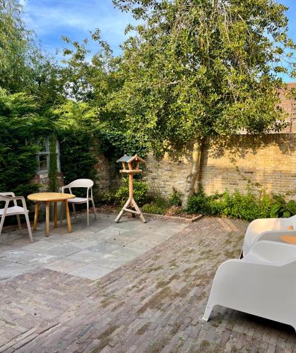 a patio with two chairs and a table and a bird feeder at Stadslogement B&B Lytse Gysbert in Bolsward