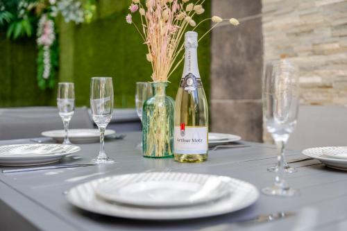 a table with glasses and a bottle of wine at Gites Spa Strasbourg - Appartement in Furdenheim
