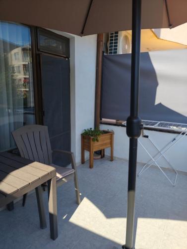 an umbrella and a chair and a television on a patio at Bo's place in St. St. Constantine and Helena