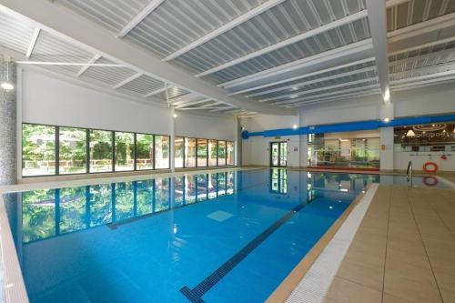 a large swimming pool with a large blue pool at Woodland Camping Pod in Hale