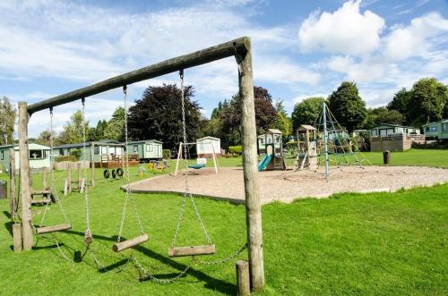 an empty playground with swings in a park at Woodland Camping Pod in Hale
