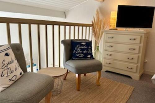 - un salon avec une chaise et une commode dans l'établissement 32 m2 apartment with swimming pool, à Saint-Martin-de-Ré