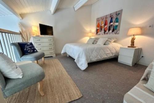 une chambre avec un lit, un canapé et une chaise dans l'établissement 32 m2 apartment with swimming pool, à Saint-Martin-de-Ré