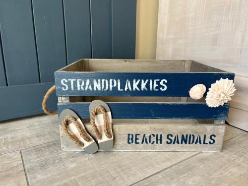 a wooden box with a pair of shoes in it at 22 on Port Natal Hartenbos in Hartenbos