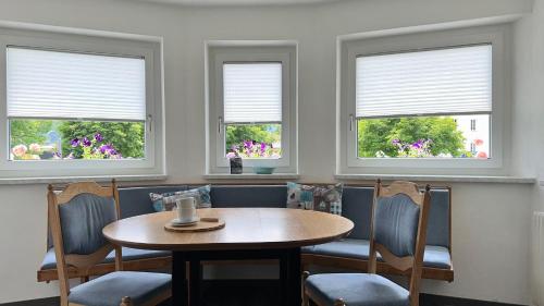 a dining room with a table and chairs and windows at Hotel Lainbach in Wängle in Reutte