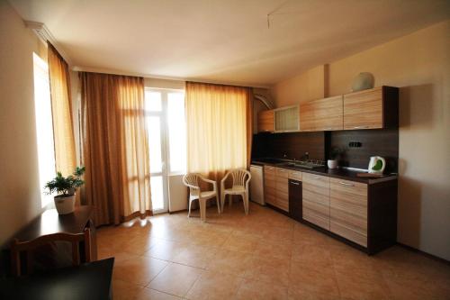 a kitchen with wooden cabinets and a table and chairs at Hotel Marant in Sozopol