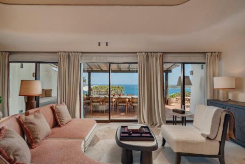 a living room with a couch and a view of the ocean at Hotel Pitrizza, Costa Smeralda in Porto Cervo
