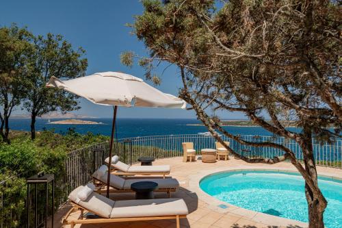 a pool with two lounge chairs and an umbrella at Hotel Pitrizza, Costa Smeralda in Porto Cervo