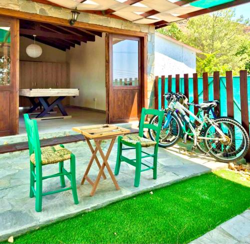 a patio with two chairs and a table and a bike at Apokas Country House in Zoopiyi