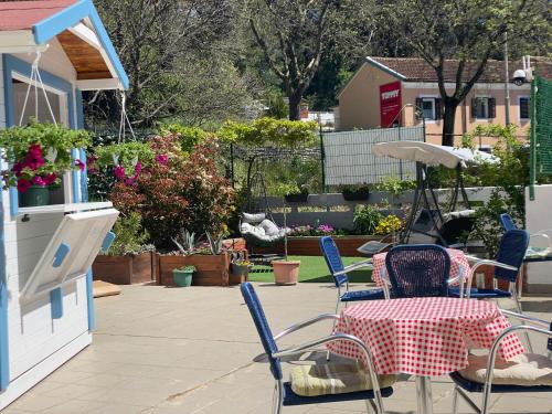 a patio with a table and chairs and flowers at Crazy House Hostel in Pula