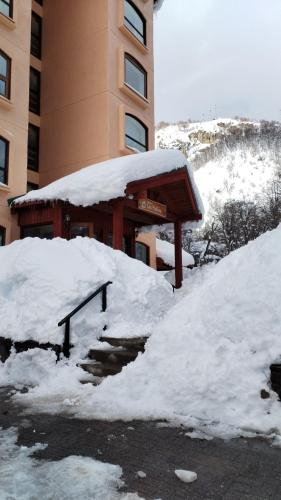 a pile of snow next to a building at Apartamento cercano a Termas de Chillán in Las Trancas