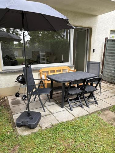 a table and chairs with an umbrella on a patio at Ferienwohnung Hennes in Remagen