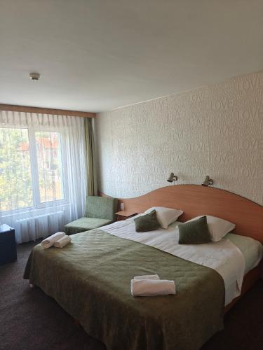 a bedroom with a large bed with two towels on it at Noviz Hotel in Plovdiv