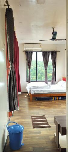 a bedroom with a bed and a large window at THE HEART OF HEAVEN in Āmbavna
