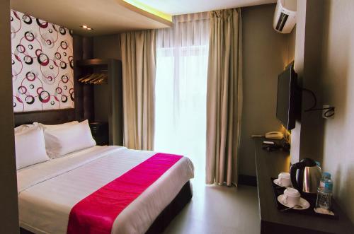 a hotel room with a bed and a window at Eloisa Royal Suites in Mactan