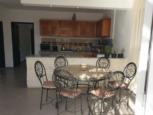a table and chairs in a kitchen with a counter at Villa famille in Ida Ougourd