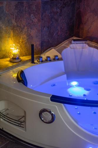 a white bath tub with a blue light in a bathroom at Aurelia Garden Suite in Rome