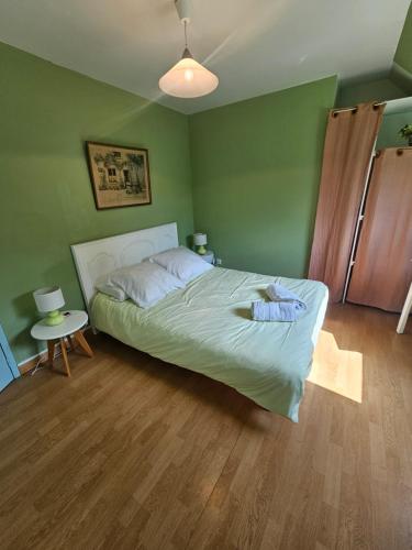 a green bedroom with a bed and a table at Chambre Gauguin - B no B les closeries du Golfe in Theix