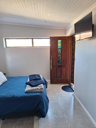 a bedroom with a bed and a window and a door at 30 on Dijon room 1 in Gqeberha