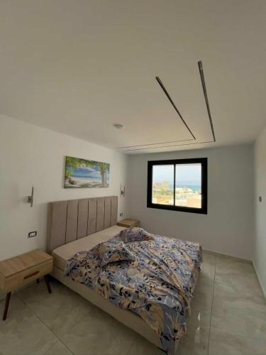a bedroom with a bed and a window at Dar ATTIA Ezzahra KELIBIA in Ḩammām al Ghazzāz