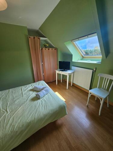 a bedroom with a bed and a chair and a window at Chambre Gauguin - B no B les closeries du Golfe in Theix