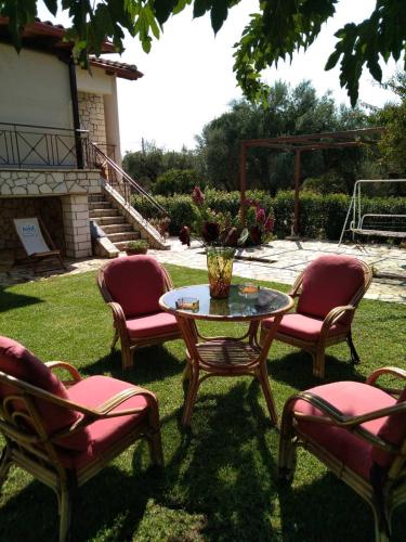 a group of chairs and a table with a vase at Spiti Loggos in Lóngos