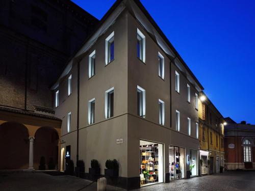 a large building with a store front at night at San Domenico in Ravenna