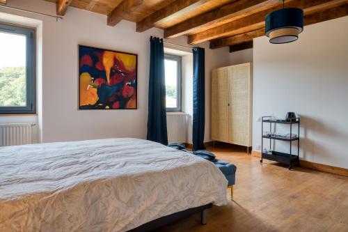 a bedroom with a bed and a painting on the wall at Chambres d'hôtes Le tour du Lot in Gorses